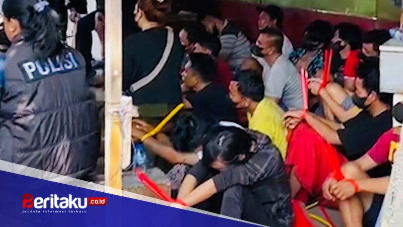 Foto: Sebanyak belasan orang dengan tangan terikat kabel ties saat didata petugas gabungan usai penggerebekan kawasan rawan peredaran gelap narkoba di Jalan Kunti, Surabaya.