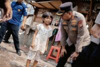 Foto: Anggota Kepolisian Polda Metro Jaya saat berinteraksi dan menyapa anak-anak warga secara ramah di sela-sela kegiatan pendampingan psikologis (trauma healing) dan bakti sosial.