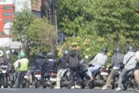 Foto: Deretan antrean panjang pengendara sepeda motor hingga meluber ke bahu jalan di salah satu SPBU di wilayah Denpasar, Bali, menyusul belum pulihnya distribusi pasokan BBM Pertamina.