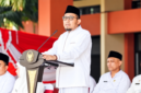 Foto: Bupati Sumenep Achmad Fauzi Wongsojudo mengenakan busana santri serba putih lengkap dengan peci hitam saat menyampaikan pidato pengarahan Hari Santri Nasional 2026 di halaman Kantor Bupati Sumenep.