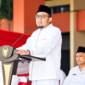 Foto: Bupati Sumenep Achmad Fauzi Wongsojudo mengenakan busana santri serba putih lengkap dengan peci hitam saat menyampaikan pidato pengarahan Hari Santri Nasional 2026 di halaman Kantor Bupati Sumenep.