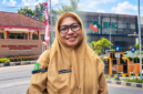 Foto: Kepala Dinkes P2KB Kabupaten Sumenep drg. Elliya Fardasah (depan) dengan latar belakang Kantor Dinas Kesehatan P2KB Sumenep (kiri) dan RS Baghraf Health Care (BHC) Sumenep (kanan).